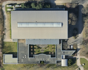 Luftaufnahme des DELTA Gebäudes. Im oberen Bereich ist die Maschinenhalle zu sehen, im unteren Bereich der Bürotrakt.
