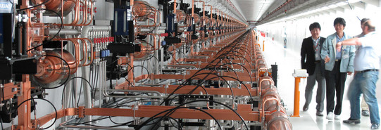 Linearbeschleuniger des Freie-Elektronen-Lasers SACLA in Japan, rechts im Bild vier Besucher