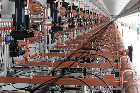 Linearbeschleuniger des Freie-Elektronen-Lasers SACLA in Japan, rechts im Bild vier Besucher